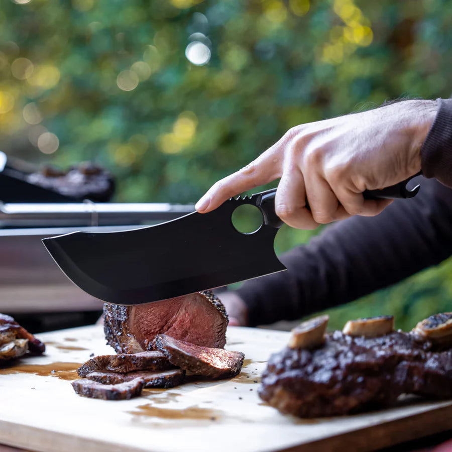 A sharp Loki knife effortlessly slicing through a juicy steak, showing its cutting power.