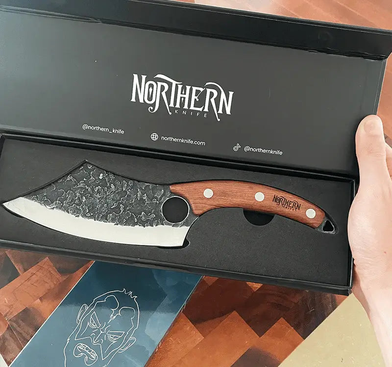 Hand holding a boxed Northern Knife with a wooden handle — a bold and elegant gift-ready presentation.