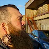Profile portrait of a bearded culinary artisan or chef representing the rugged, professional identity of the Northern Knife brand.
