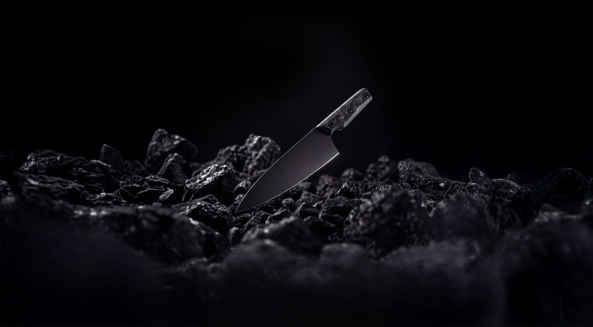 ONYX Series 8 inch chef knife resting on black coal
